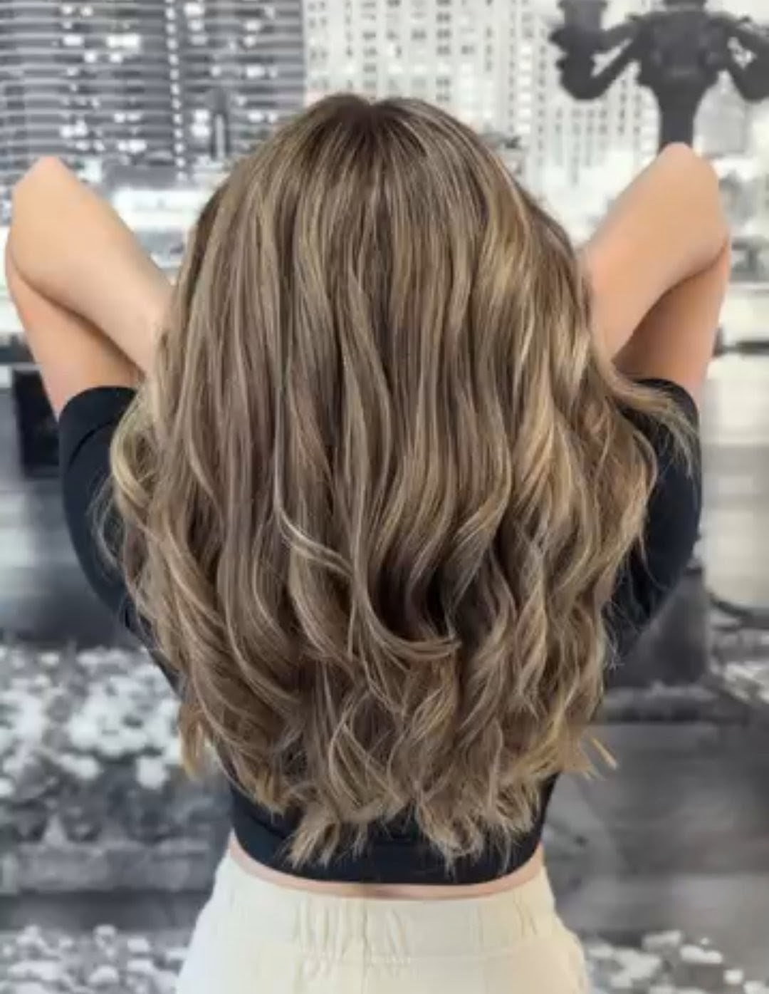 Back view of long, voluminous waves with soft bronde balayage