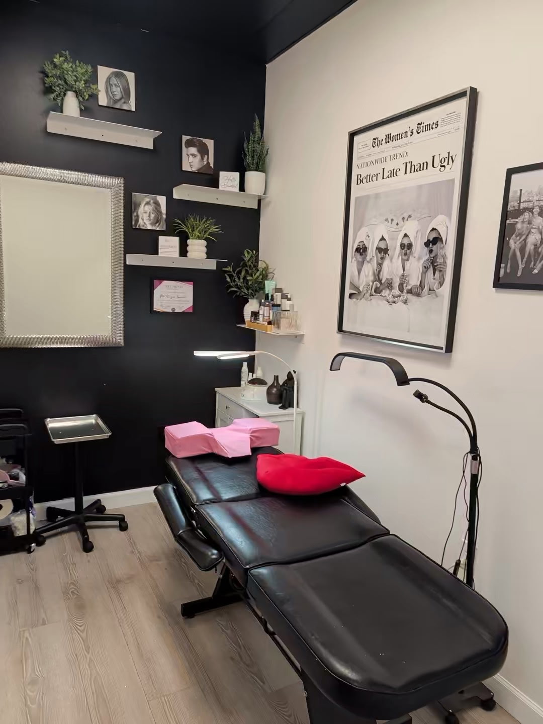 Private treatment room with a treatment bed, red lip pillow, and vintage portraits